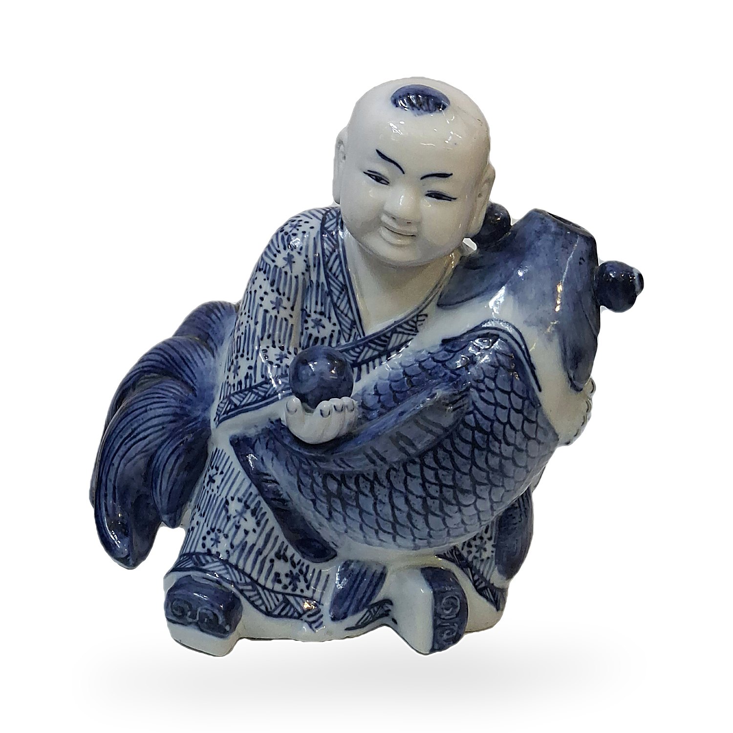 Figura de niño abrazando un pez koi en cerámica azul y blanca
